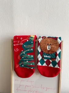 Detailed shot of Christmas cotton socks with cute bear and tree pattern, festive winter style.