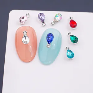 Detailed view of colorful teardrop nail rhinestones with double crystal alloy base for sparkling art.