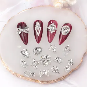 Detailansicht von Silberlegierung Nagelkunst Strasssteinen und klaren Kristall-Charms.