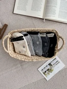 Detail view of cute floral embroidered mid-calf socks with lettuce trim in cozy cotton.