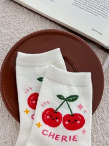 Detail shot of cute white cotton mid-tube socks featuring sweet cherry knit pattern.