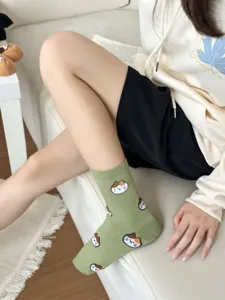 Detail shot of cute cat pattern green mid-tube socks, soft combed cotton daily wear.