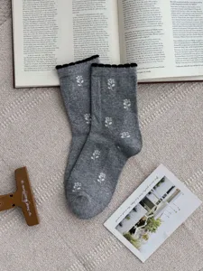 Women gray combed cotton mid tube socks with white tulip pattern and black bubble ruffled cuffs.