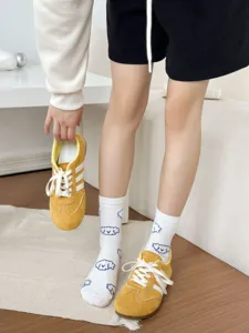 Cute animal pattern mid-tube cotton socks paired with stylish casual sneakers detail view.