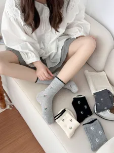 Detailed view of women cute tulip embroidered cotton mid-calf socks with ruffled bubble cuffs.