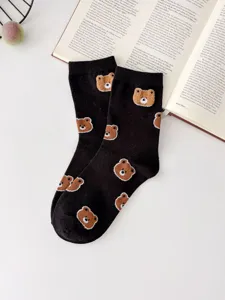 Close-up detail of black cute bear embroidered crew socks, soft combed cotton, aesthetic flatlay.
