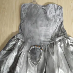 Detail van zilvergrijs strapless kantjurkje met bijpassend haaraccessoire voorfeest