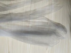 Gedetailleerd overzicht van lichte grijze tulle mesh stof, zacht en ademend voor kostuums.