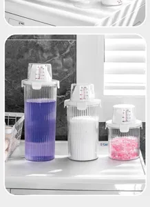 Clear laundry detergent storage jar with measuring cup, transparent plastic powder container.