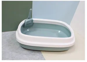 Vue détaillée d'un bac à litière pour chat semi-fermé en plastique vert et blanc avec pelle incluse.