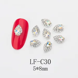 Detail shot of teardrop nail rhinestones featuring iridescent AB crystals and sparkling alloy trim.