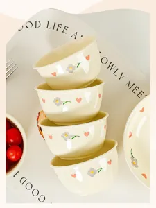 Ceramic rice bowl detail featuring cute flower and heart underglaze patterns for kitchen use.