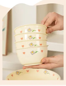 Detailed view of cream style ceramic rice bowl set featuring cute grey floral and pink heart patterns.