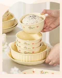 Detail shot of cream style ceramic rice bowl set featuring cute floral and heart underglaze patterns.