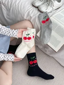 Close up detail of cute cherry pattern cotton mid socks with cozy bedroom lifestyle background.