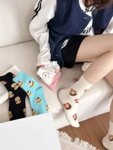 Close-up detail of cute cartoon bear donut pattern women cotton crew socks in multiple colors.