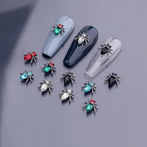 Detailaufnahme von Retro-Alu-Spinnen-Nagelanhängern mit funkelnden Strasssteinen für gotische Nailart.