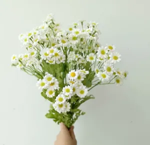 Close-up of artificial chamomile flower bouquet, fresh white daisy details for home decor.