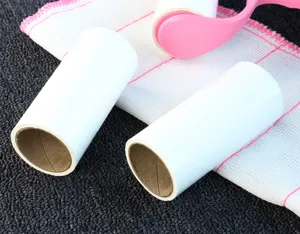 Close-up detail shot of replacement lint roller refill cores and a pink handle for cleaning.