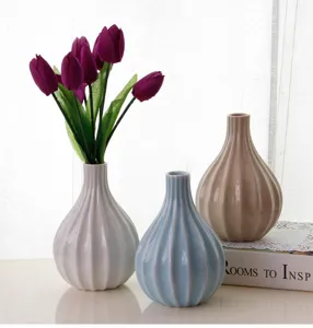 Ceramic vase detail showing striped texture and pastel colors with tulip arrangement.