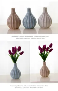 Detail shot of elegant ceramic vases with vertical ribbed design and matching tulip flower decor.