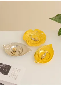 Detail view of modern creative metal leaf incense holders with cute snail figurines for home decor.