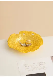 Close-up detail of the creative lotus leaf metal dish and snail incense holder, elegant desktop decor.