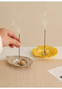 Close-up detail of creative metal leaf incense holder with cute snail sculpture for aromatherapy.