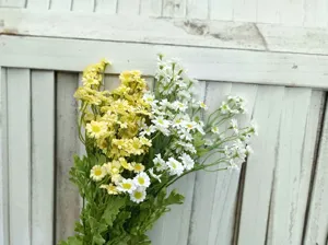 Close-up detail of artificial chamomile daisy flower bouquet, fresh home decor arrangement.