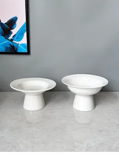 Detail view of modern minimalist white ceramic footed fruit plate and dessert display.