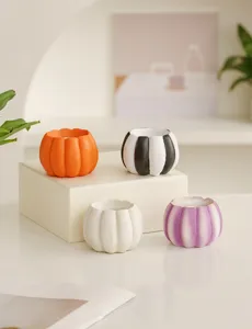 Detail view of multi-color resin pumpkin candle holders, perfect for minimalist festive table decor.