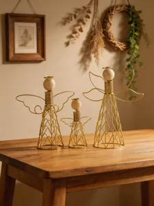 Detailed view of the modern metal wire and wooden angel figurines displayed nicely on a wooden table.