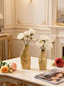 Vue détaillée de vase en céramique dorée de luxe avec roses, élégant décor de table.