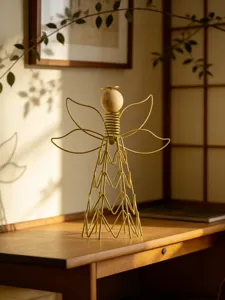 Minimalist wire art angel ornament detail shot, modern gold metal and wood decor piece.