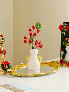 Detailed close-up view of the white ceramic angel vase with red berries on gold tray.