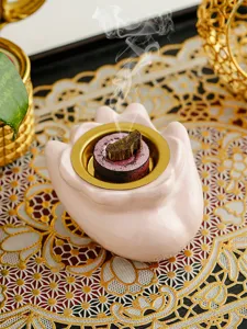 Primo piano dettagliato del bruciatore di incenso in ceramica a forma di mano elegante.