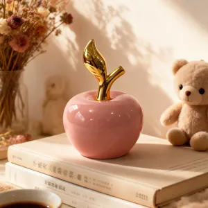 Mela in ceramica rosa con stelo dorato, decorazione d'interni moderna per scrivania.