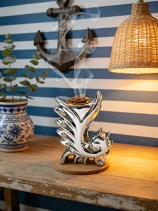 Vista dettagliata del bruciatore d'incenso in ceramica argentata con legno nella stanza.
