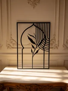 Metal wall art detail shot showing abstract leaf and arch design against classic background.