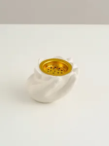 Primo piano di bruciatore di incenso in ceramica bianca a forma di mano con piatto d'oro.