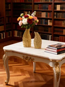 Vue détaillée de vases en céramique dorée en forme de feuille sur une table en marbre.