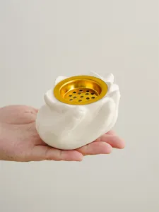 Primo piano dettagliato di un bruciatore di incenso in ceramica tenuto in mano con inserto.
