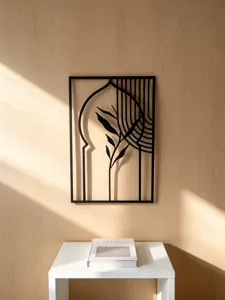 Metal wall art hanging with modern arch and leaf design, perfect for stylish home decor.