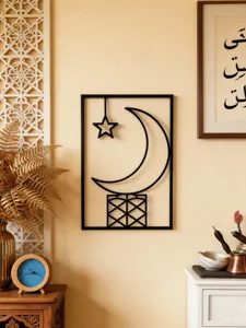 Detailed view of black metal crescent moon and star wall art hanging in warm home interior.