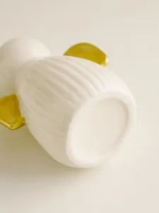 Ceramic angel vase detail view, elegant white fluted body with shiny gold wings for home decor.