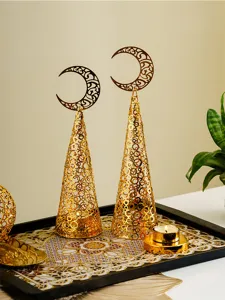 Close-up of gold hollow metal cone candle holders with moon top on cozy holiday tray decor.