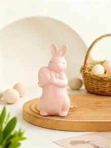 Detailed close-up shot of the cute ceramic Easter bunny holding egg for home decor setup.
