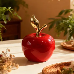 Vista dettagliata dell'ornamento di mela in ceramica rossa moderna con stelo dorato, elegante.