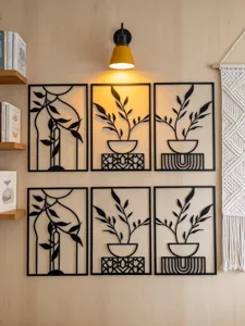 Modern black metal wall art set featuring botanical leaf and vase designs for elegant home decor.