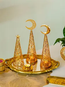 Detailed view of golden metal hollow-out Christmas tree candle holders on a mirror tray.